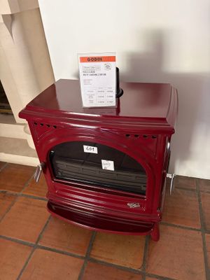 a small red stove with a menu on top of it