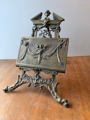 an antique brass desk with a mirror on top of it on a wooden table