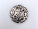 an old silver coin on a white surface with a white background
