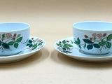 deux tasses et soucoupes ornées de fleurs, posées sur une table