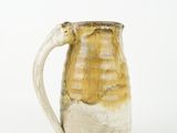 a close up of a ceramic pitcher on a white background