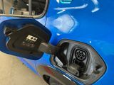 a blue car with a fuel pump attached to it ' s side