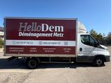a delivery truck parked in a parking lot with a hello den sign on the side of the truck