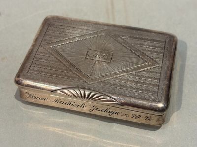a silver box with a design on it sitting on a table