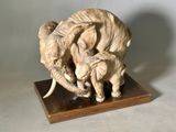 statue représentant deux éléphants dotés de défenses, posée sur un socle en bois