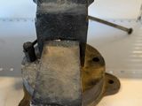 a metal vise on a table with a hammer in it