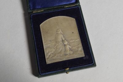 une petite plaque en argent dans un écrin bleu