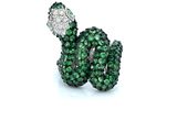 an image of a close up of a snake ring with green and white stones