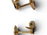 two pairs of gold plated cufflinks on a white surface