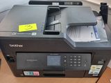 a printer that is sitting on a desk in front of a window