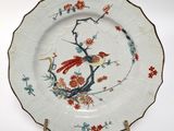 a plate with a bird and flowers on it