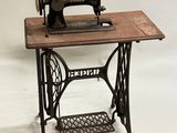 une vieille machine à coudre posée sur une table en bois