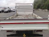 a white truck with a red stripe parked in a parking lot