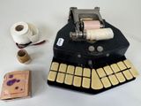 a machine that is sitting next to a roll of toilet paper