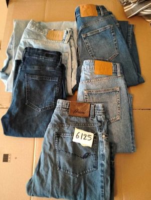 Plusieurs paires de jeans sont empilées sur une boîte en carton
