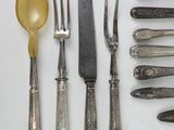 a lot of silverware on a table with spoons and knives