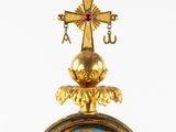 an image of a gold and blue clock with a cross on top of it