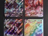 quatre cartes Pokémon différentes posées sur une table noire