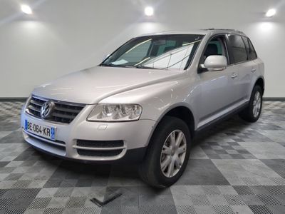 la voiture argentée est garée dans le garage sur le sol en damier