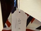 a black vase with a tag on it sitting on a table