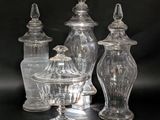 three clear glass jars with lids on a black surface