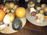 deux assiettes de fruits posées sur une table, avec un tableau accroché au mur