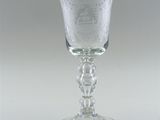 a glass with a design on it sitting on a table