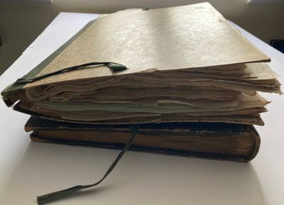 une pile de livres posée sur une table, sur laquelle se trouvent une paire de lunettes