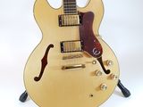 an electric guitar sitting on top of a stand on a white surface
