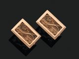 une paire de boucles d'oreilles en or aux motifs raffinés sur fond noir