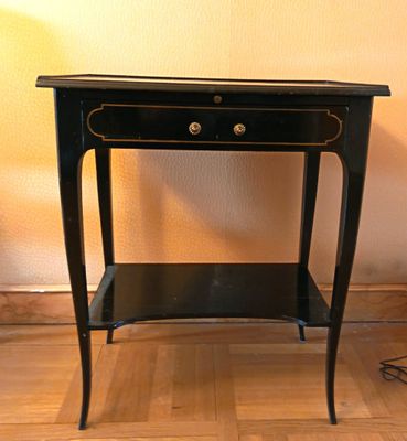 une petite table noire surmontée d'un tiroir