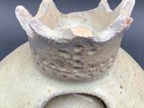 a white vase with a crown on top of it