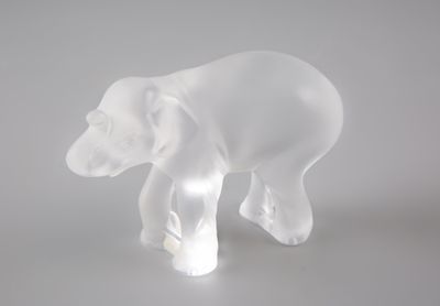 une sculpture en verre transparent représentant un ours, posée sur une table