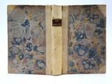 un vieux livre ouvert sur une surface blanche