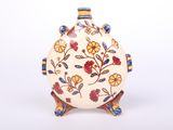 a white vase with a floral design on it