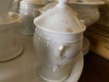 many white dishes and cups on the table