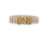 un gros plan d'une bague en or ornée de perles sur fond blanc