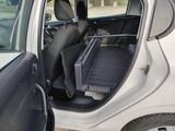 a small white car with the door open and the back seat down