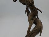 bronze statue of a woman holding a bird on a branch