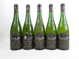 six bouteilles de vin sont alignées sur une surface blanche