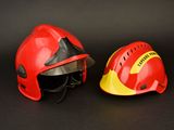 pair of red and yellow firefighter ' s helmets on a black background