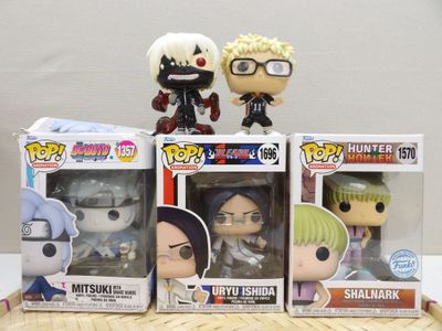 trois figurines en vinyle au style pop et original représentant des personnages d'anime, exposées dans une vitrine