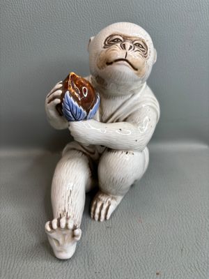 une figurine représentant un singe tenant un beignet