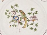 an image of a plate with a bird and flowers on it