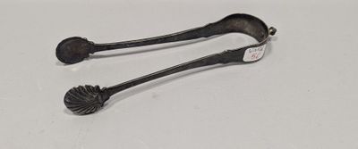 une paire de cuillères anciennes en argent posées sur une surface blanche