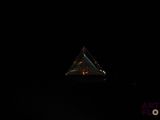 an image of a triangle shaped object is lit up in the dark