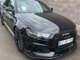 the black audi rs4 is parked in front of a brick wall