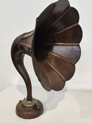 un vieux gramophone posé sur une surface blanche, avec un fond blanc