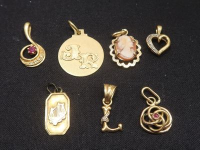 a collection of gold and silver jewelry including a pendant, a pendant, a pendant, and a pendant