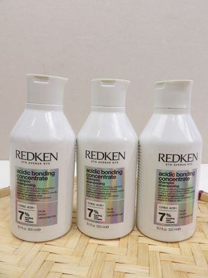 three bottles of redken hair products sitting on a table